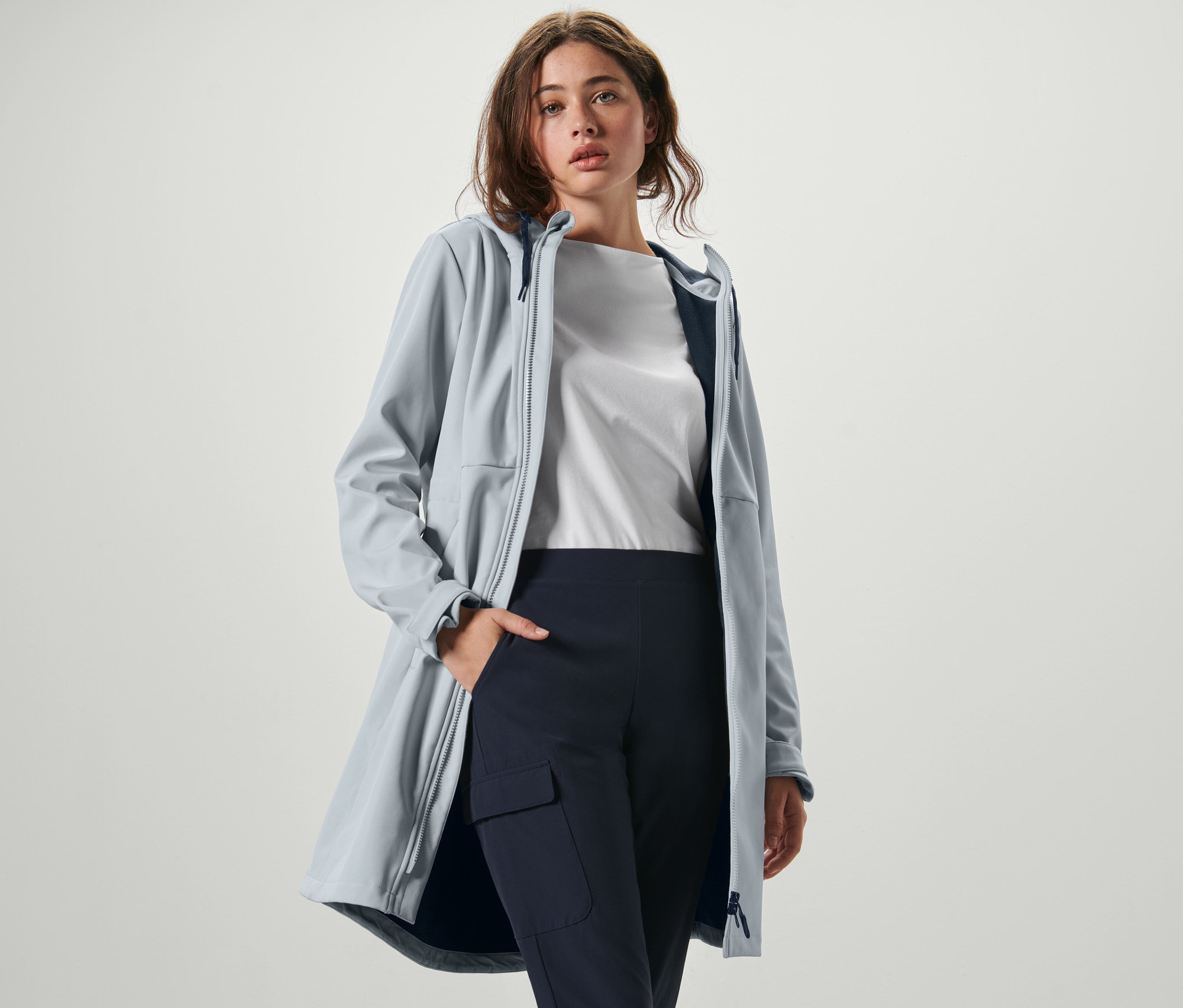 Frau posiert in einem icegrauen Softshellmantel.