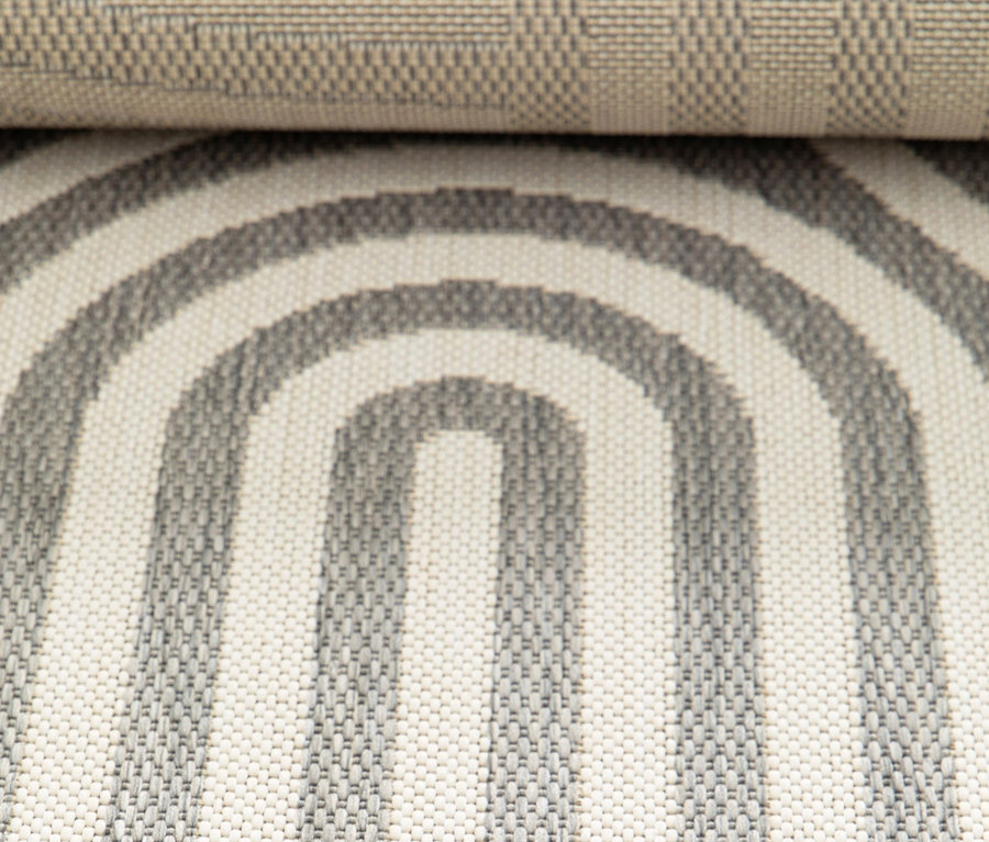 Nahaufnahme eines Outdoor-Teppichs »Arc Symphony« mit grau-weißen Bögen.