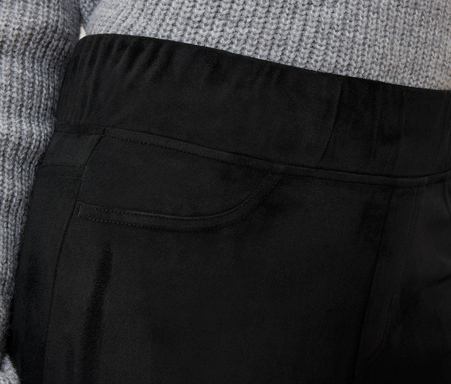 Detailaufnahme einer schwarzen Damenhose mit Tasche und grauem Pullover.