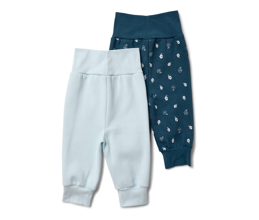 Zwei Baby-Sweathosen: eine hellblaue und eine dunkelblaue mit kleinen weißen Booten bedruckt.
