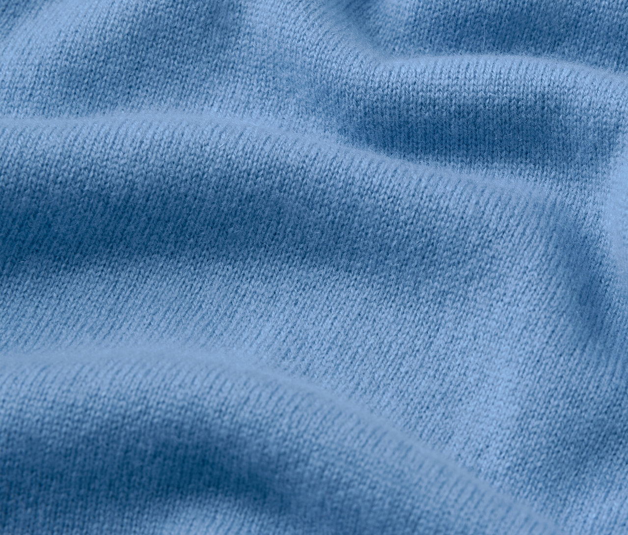 Detailaufnahme eines hellblauen Wollpullovers.