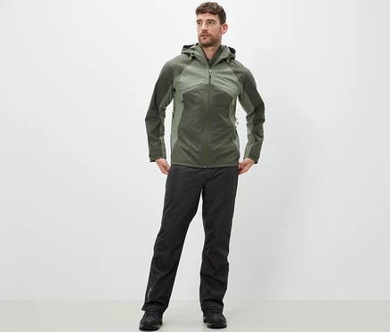 Mann steht und trägt eine High-Tech-Regenhose und eine Jacke.