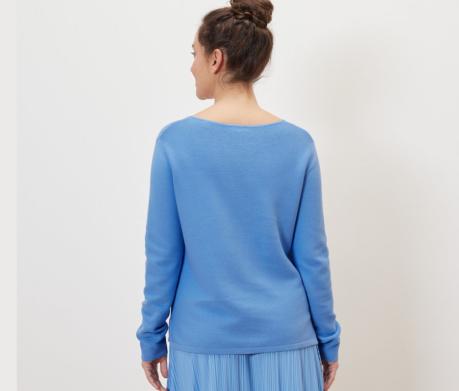 Frau trägt hellblauen Strickpullover.