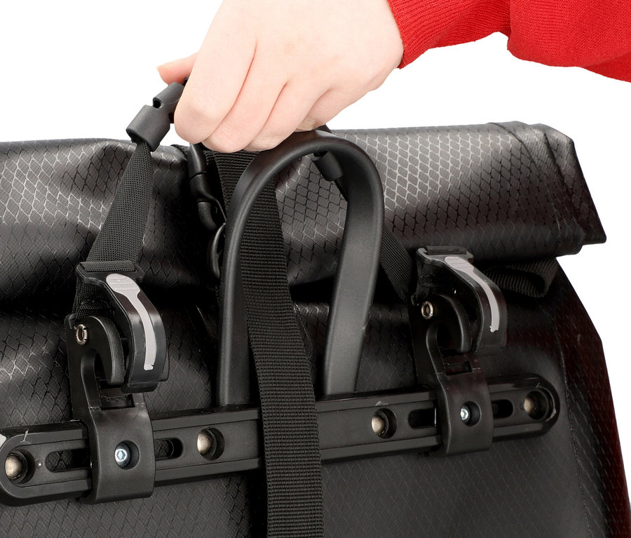 Hand schließt eine schwarze Fahrradtasche.