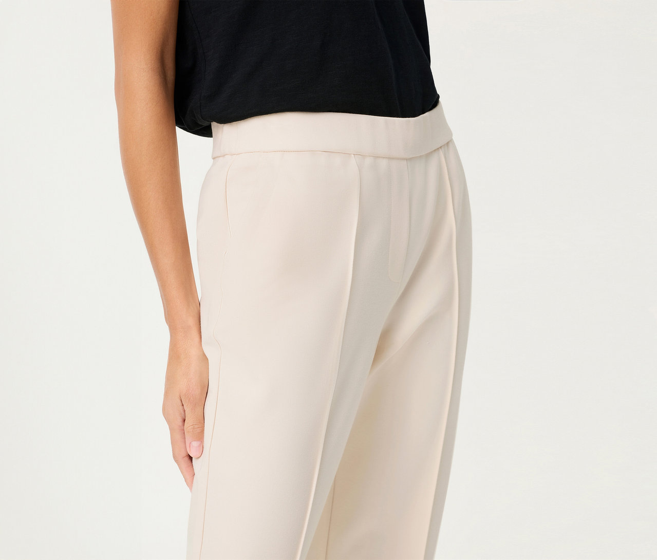 Frau trägt eine Olsen Leinen-Hose, cropped, mit einem schwarzen Oberteil vor einem weißen Hintergrund.