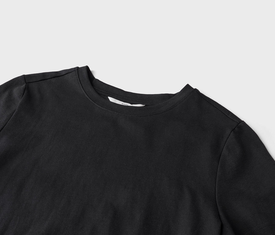 Detailaufnahme eines schwarzen T-Shirts mit Rundhalsausschnitt auf hellgrauem Hintergrund.