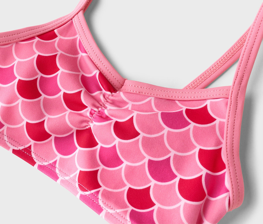 Nahaufnahme eines pinkfarbenen Oberteils mit Fischschuppenmuster.