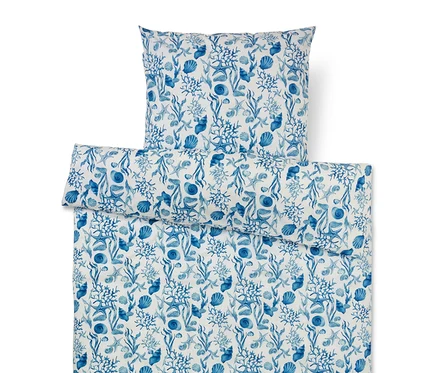 Bettwäsche-Set mit blauem Meeresmuster aus Korallen, Muscheln, Seesternen und Algen auf weißem Grund.