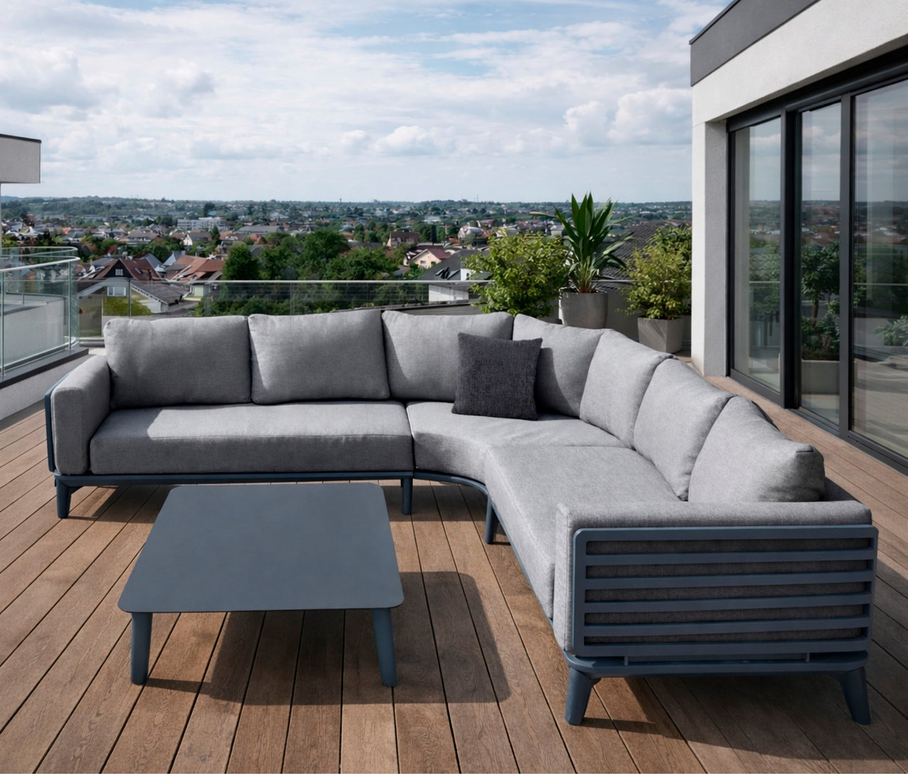 Auf einer Terrasse steht eine anthrazitfarbene Leco Lounge-Ecke »Moss« mit Tisch. Im Hintergrund ist eine Stadt zu sehen.