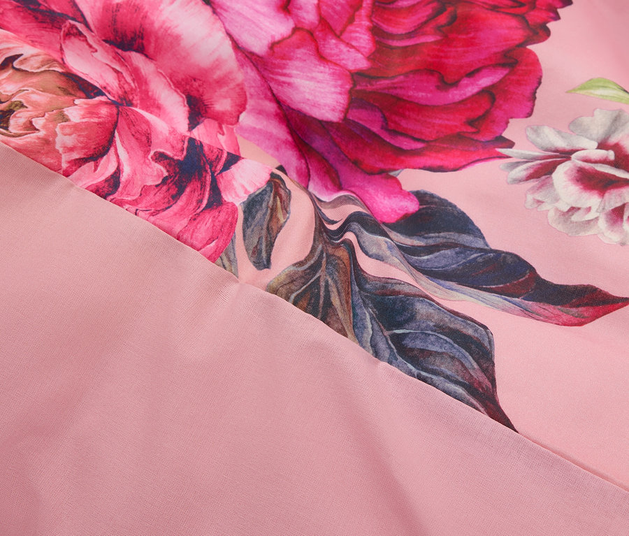 Nahaufnahme eines rosa Stoffes mit einem Blumenmuster.