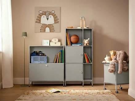 Einrichtungsgegenstände in einem Kinderzimmer mit einem beigen Teppich »Himalaya« und einer salbeifarbene LED-Akku-Outdoor-Stehleuchte.
