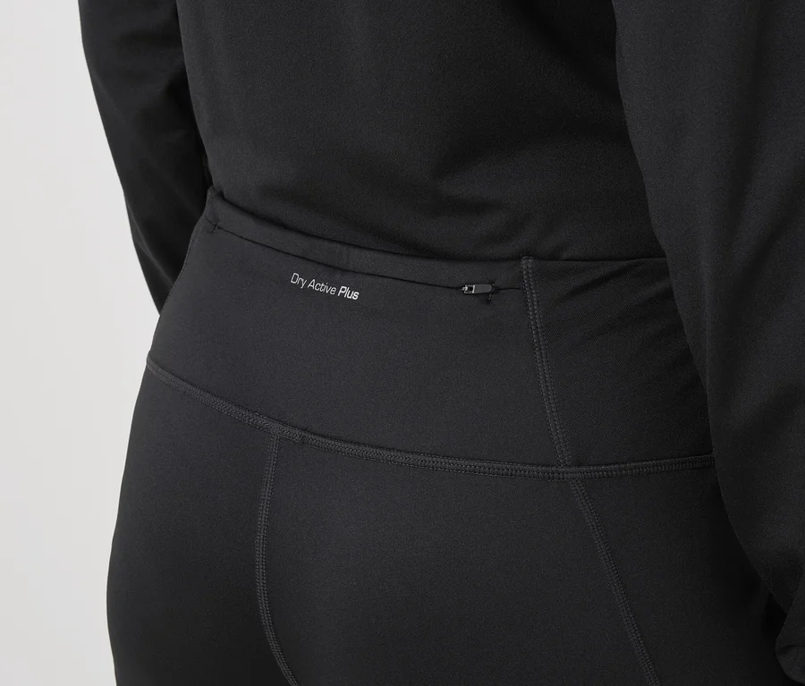 Nahaufnahme von schwarzer Sportbekleidung mit dem Schriftzug „Dry Active Plus“ und einer Reißverschlusstasche.
