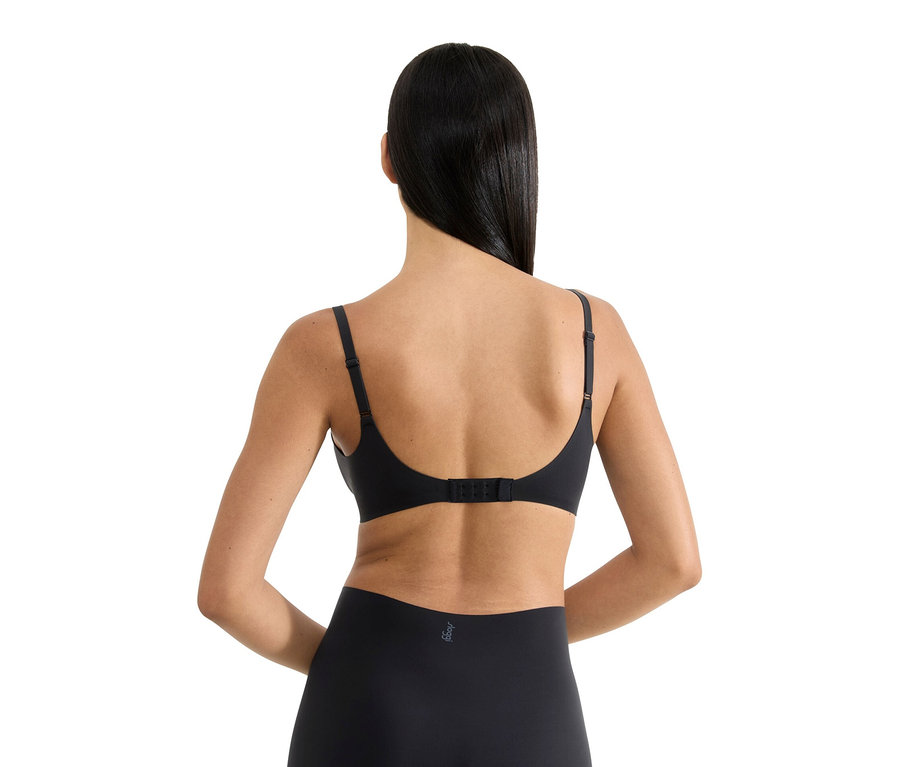 Rückansicht einer Frau mit langen, dunklen Haaren, die einen schwarzen BH und Unterwäsche trägt.