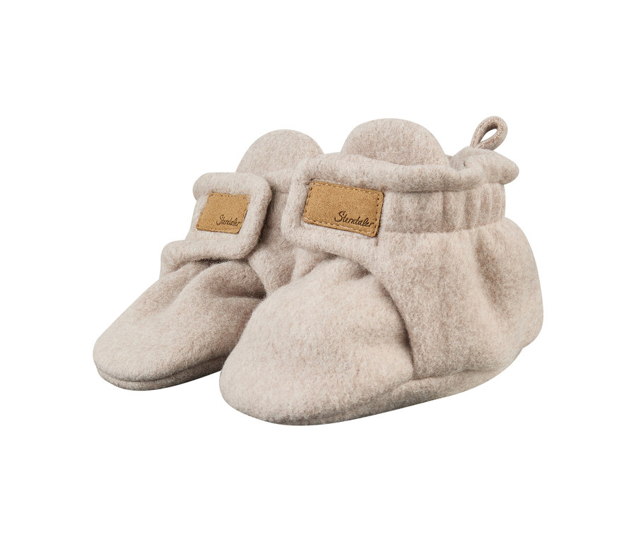Ein Paar hellbeige Babyschühchen aus weichem, filzähnlichem Material, mit Klettverschlussklappe und braunem „Sterntaler“-Etikett.