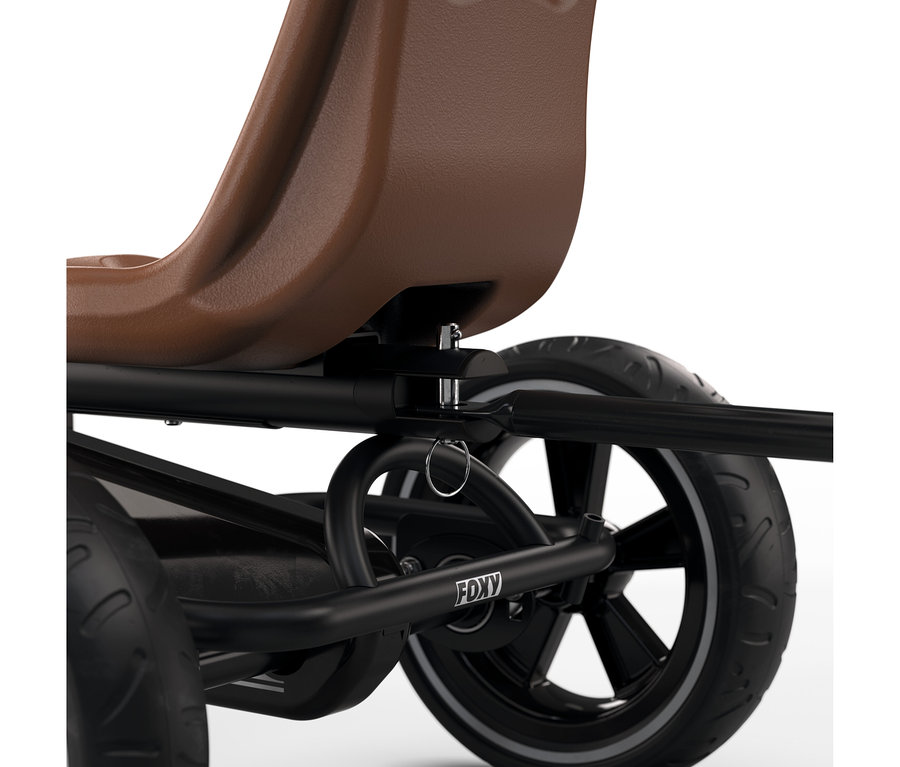 Nahaufnahme des hinteren Teils eines schwarzen Go-Karts mit braunem Sitz. Der schwarze Rahmen hat einen silbernen Verstellstift und einen silbernen Ring. Ein schwarzes Rad mit weißer Seitenwand ist sichtbar, und das Wort 'FOXY' ist auf dem Rahmen aufgedruckt.