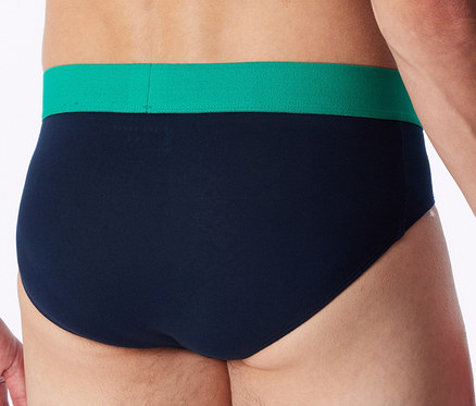 Rückenansicht einer Person, die marineblaue Slips mit grünem Bund trägt.