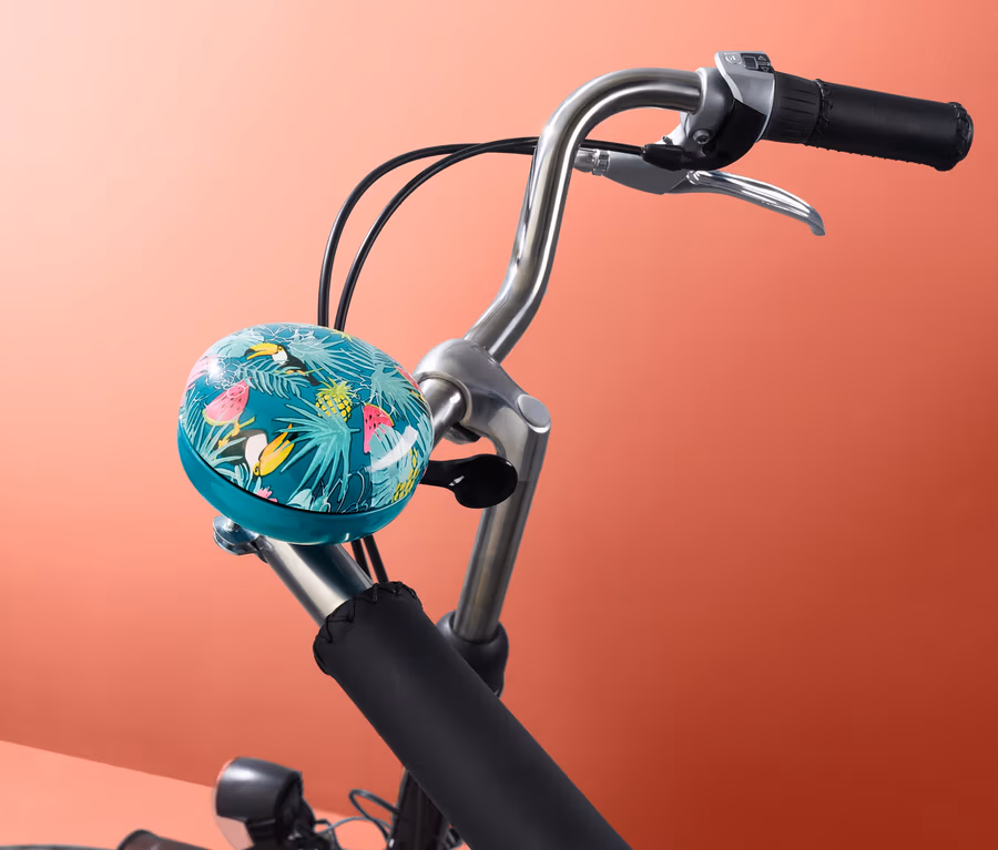 Fahrradlenker mit einer Fahrradklingel mit Tukan-Muster.