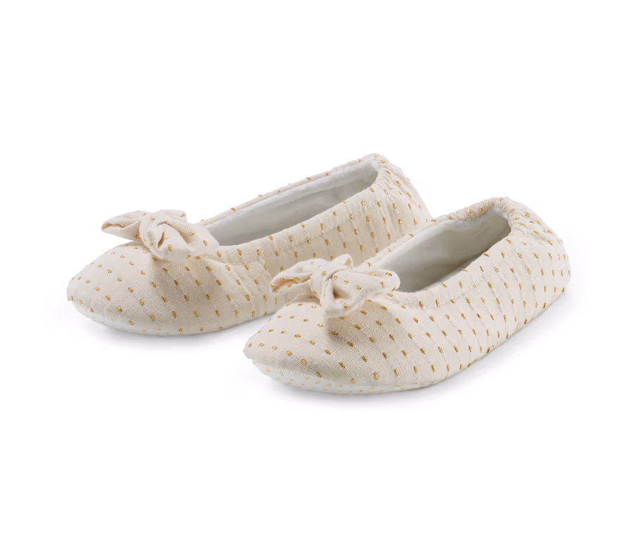 Zwei beige Ballerina-Hausschuhe mit Schleife und goldenen Punkten.