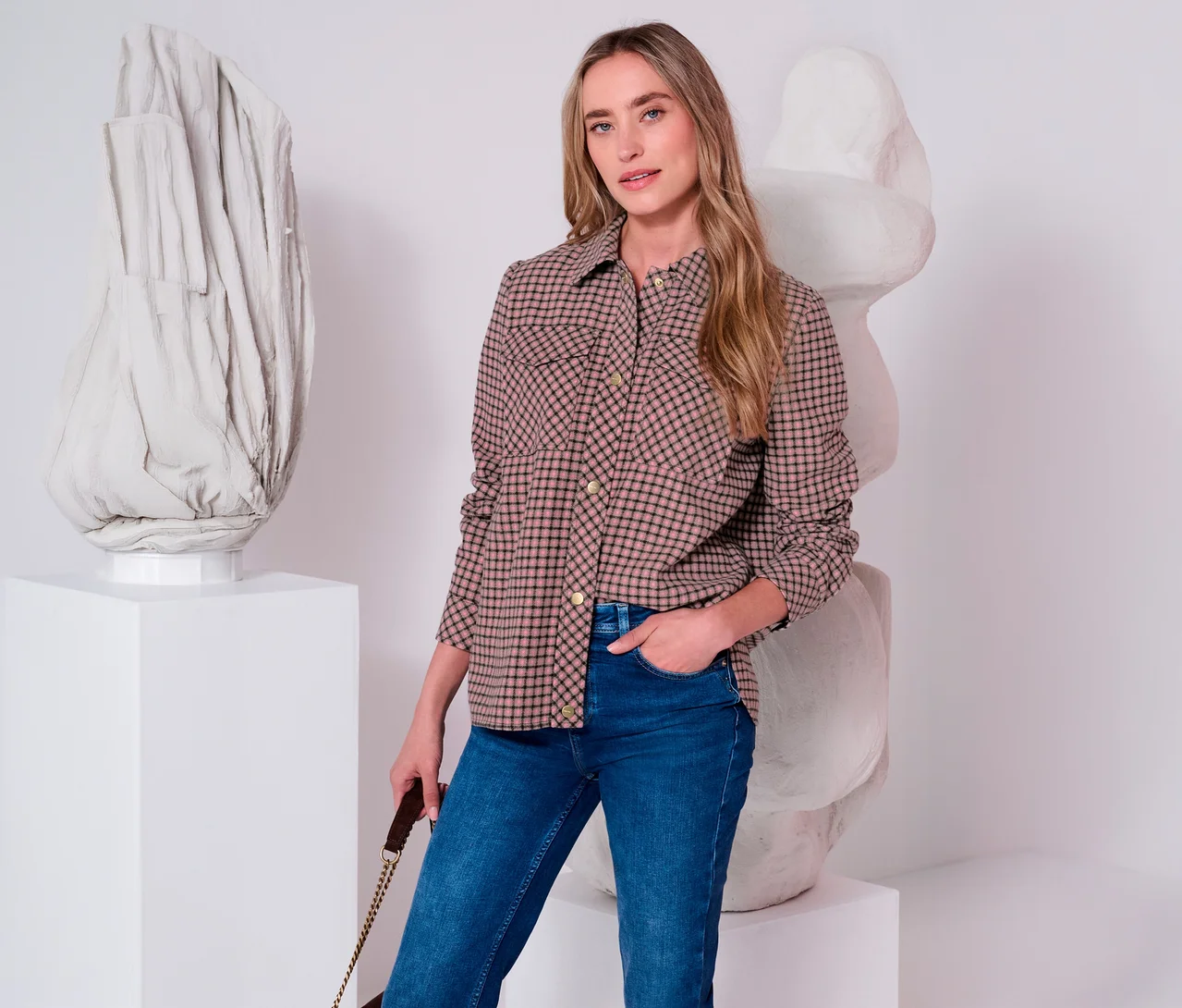Frau trägt eine karierte Street One Jacke in Beige und Schwarz und blaue Jeans, mit der Hand in der Tasche.