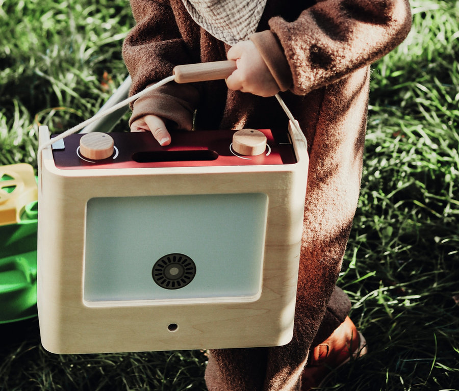 Junge im braunen Overall spielt mit small foot Kinderküche Camping »tasty« im Gras.