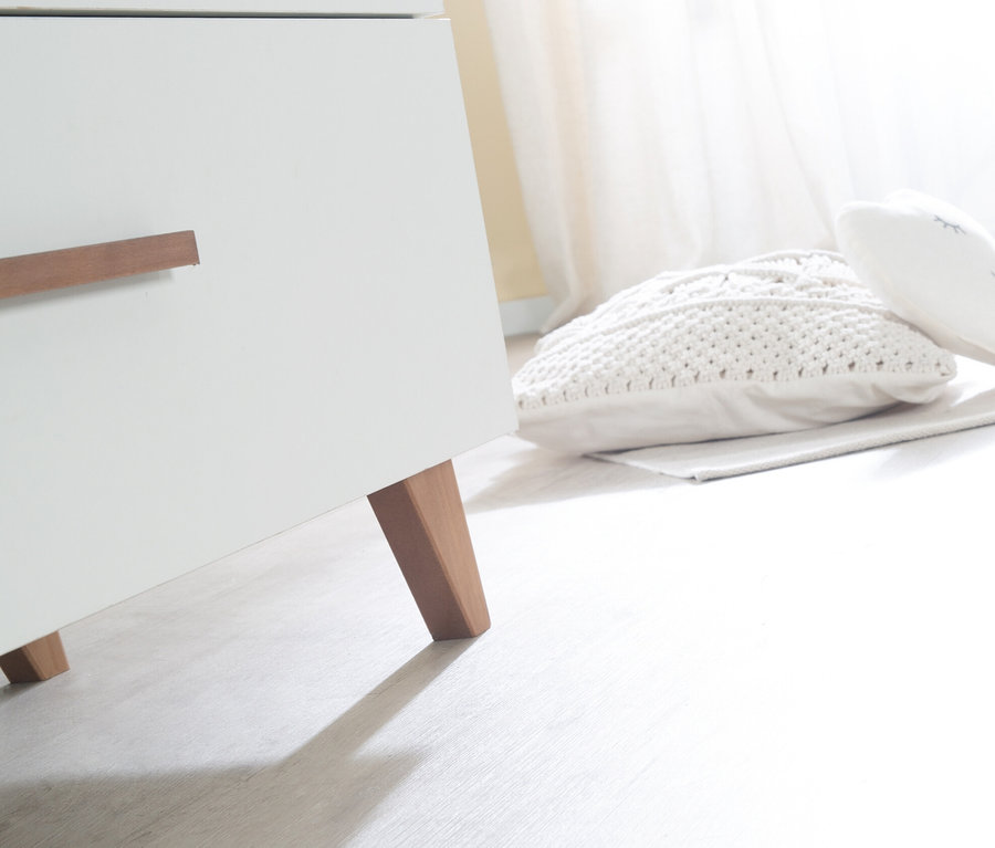 Detail eines weißen roba Kinderzimmersets »Ole« mit Kommode, Holzfüßen und Kissen.