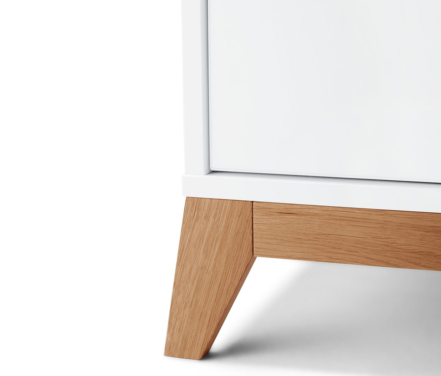 Detailansicht einer weißen Wickelkommode mit Holzfüßen.