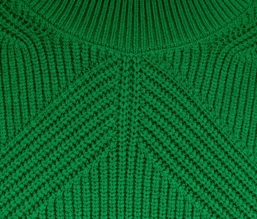 Detailansicht der Textur eines Grobstrickpullovers.