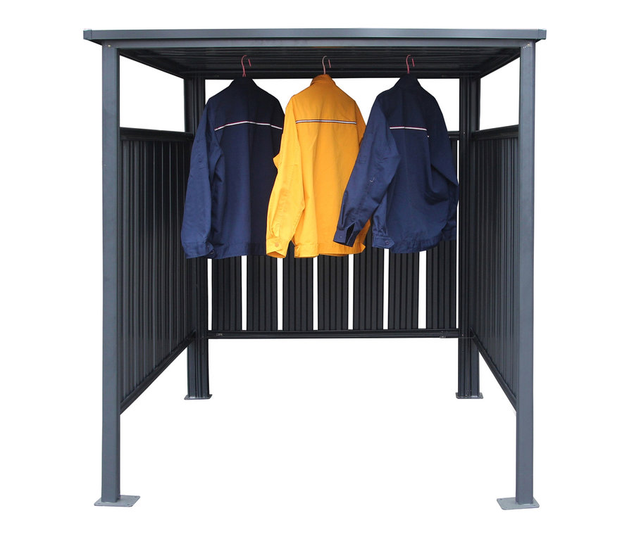 Zwei blaue und eine gelbe Jacke hängen in einem Fahrradunterstand an Kleiderbügeln.