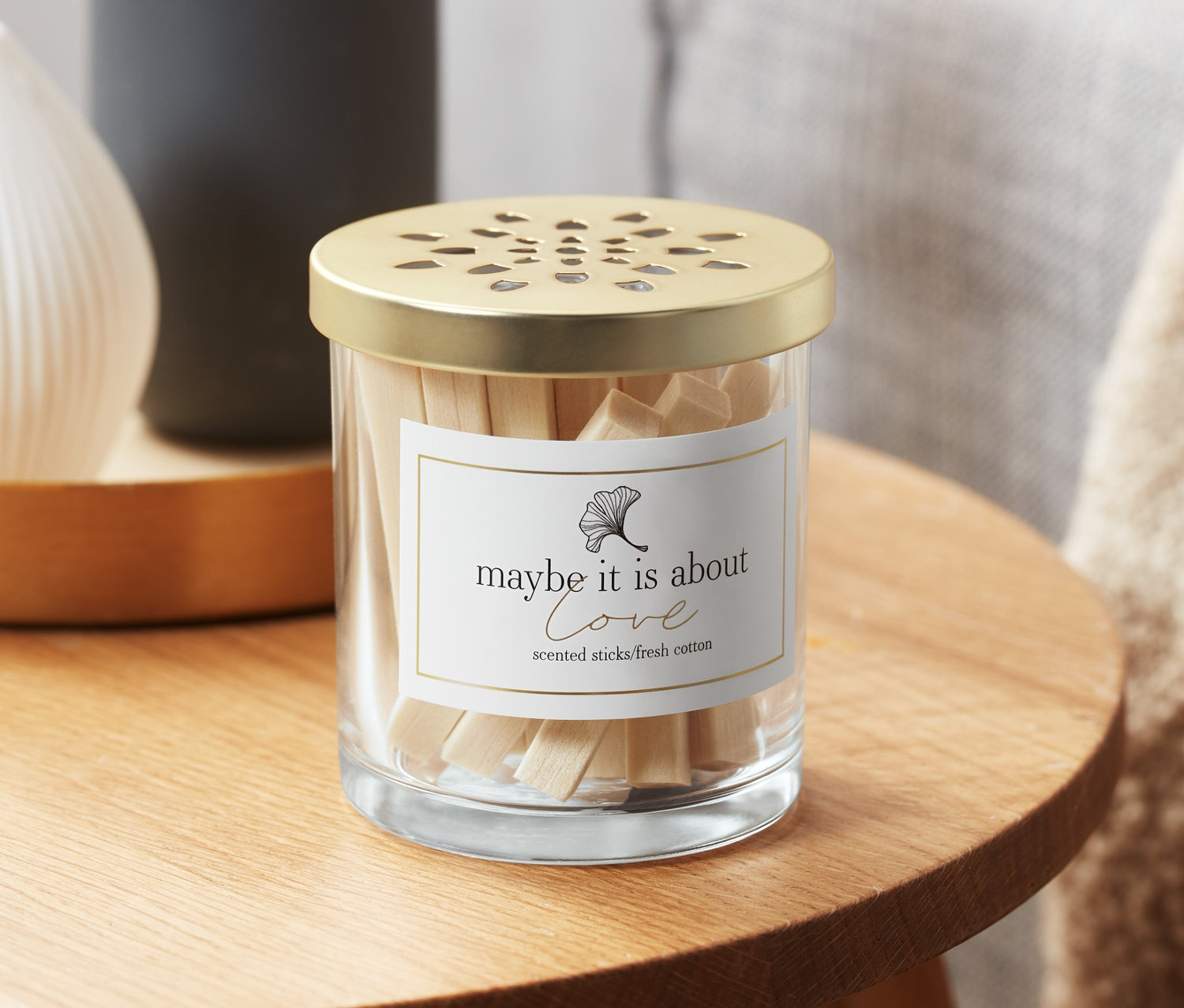 Glasbehälter mit Raumduft-Sticks, Baumwollfelder, auf einem Holztisch.