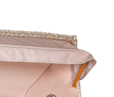 Ein geflochtener Strandkorb mit beigen Polstern und Holzelementen.