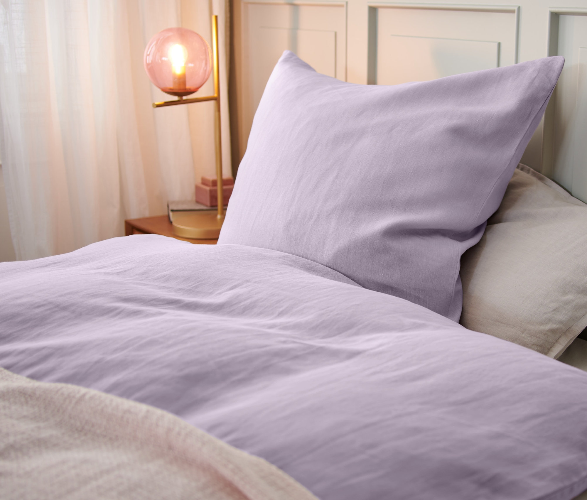 Detailansicht von fliederfarbener Bettwäsche aus Leinen.