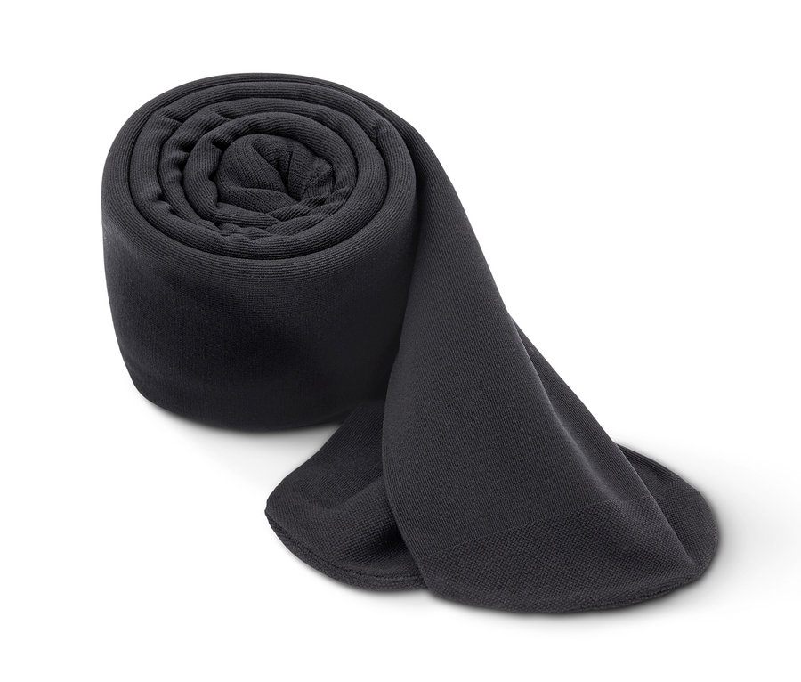 Ein Paar zusammengerollte, blickdichte, schwarze Strumpfhosen auf weißem Grund.