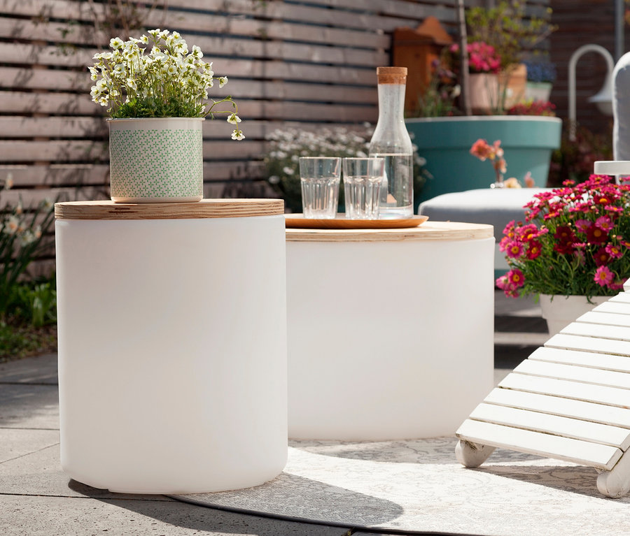 Außenszene mit zwei weißen 8 seasons design LED-Leuchten, auf einer davon steht ein Blumentopf.