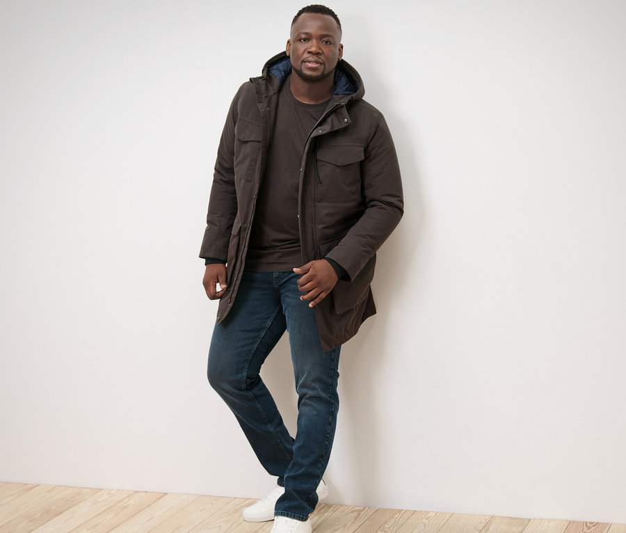 Mann posiert in Parka und 2 Langarmshirts.