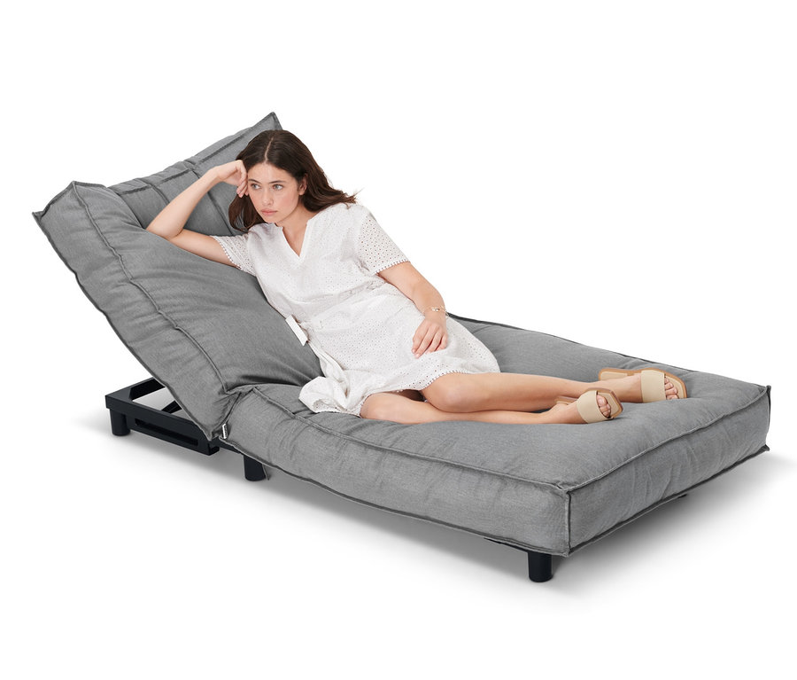 Eine Frau liegt auf einer Premium-Einzelliege mit verstellbarem Kopfteil.