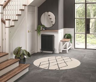 Eingangsbereich mit rundem Teppich »NOMAD Rhombus Line« und Treppe.