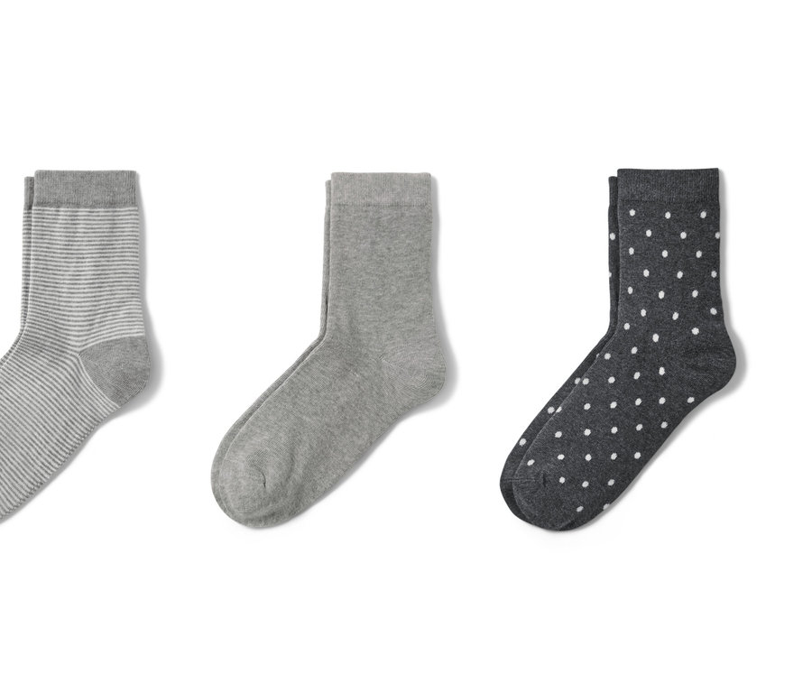 Drei Paar graue Socken: ein Paar gestreift, ein Paar einfarbig und ein Paar gepunktet.