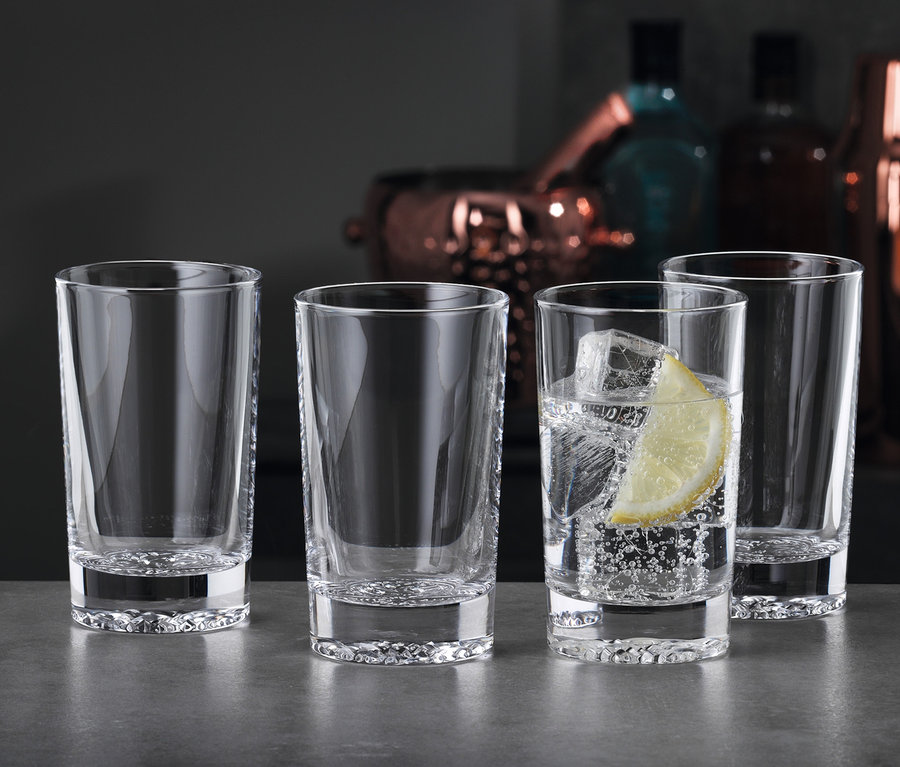 Vier Spiegelau Softdrinkgläser »Lounge 2.0« stehen auf einem Tisch, eines mit Eis und Zitrone.