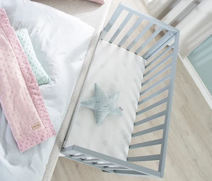 Draufsicht auf roba 2-in-1-Beistellbett »safe asleep®«, taupefarben, mit Stern, und Bett mit rosa Kissen.