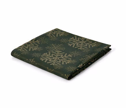 Eine grüne Jacquard-Tischdecke mit goldenen Schneeflocken.