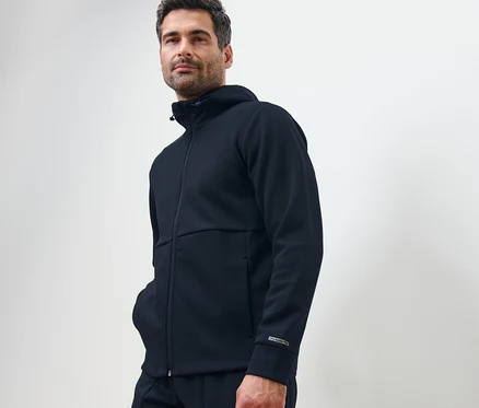Mann posiert in dunkelblauer Funktionssweatjacke.