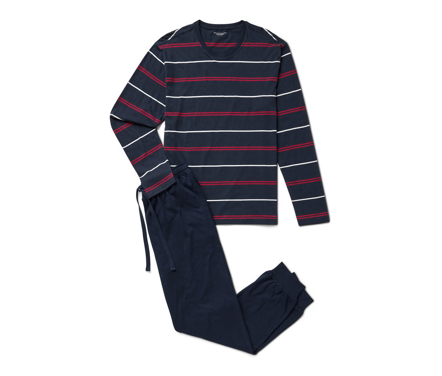 Ein marineblauer Pyjama mit Streifen liegt.