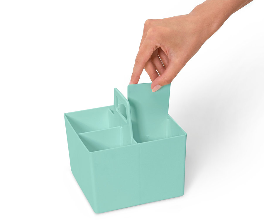 Eine Hand setzt eine Trennwand in einen hellblauen Organizer mit mehreren Fächern ein.