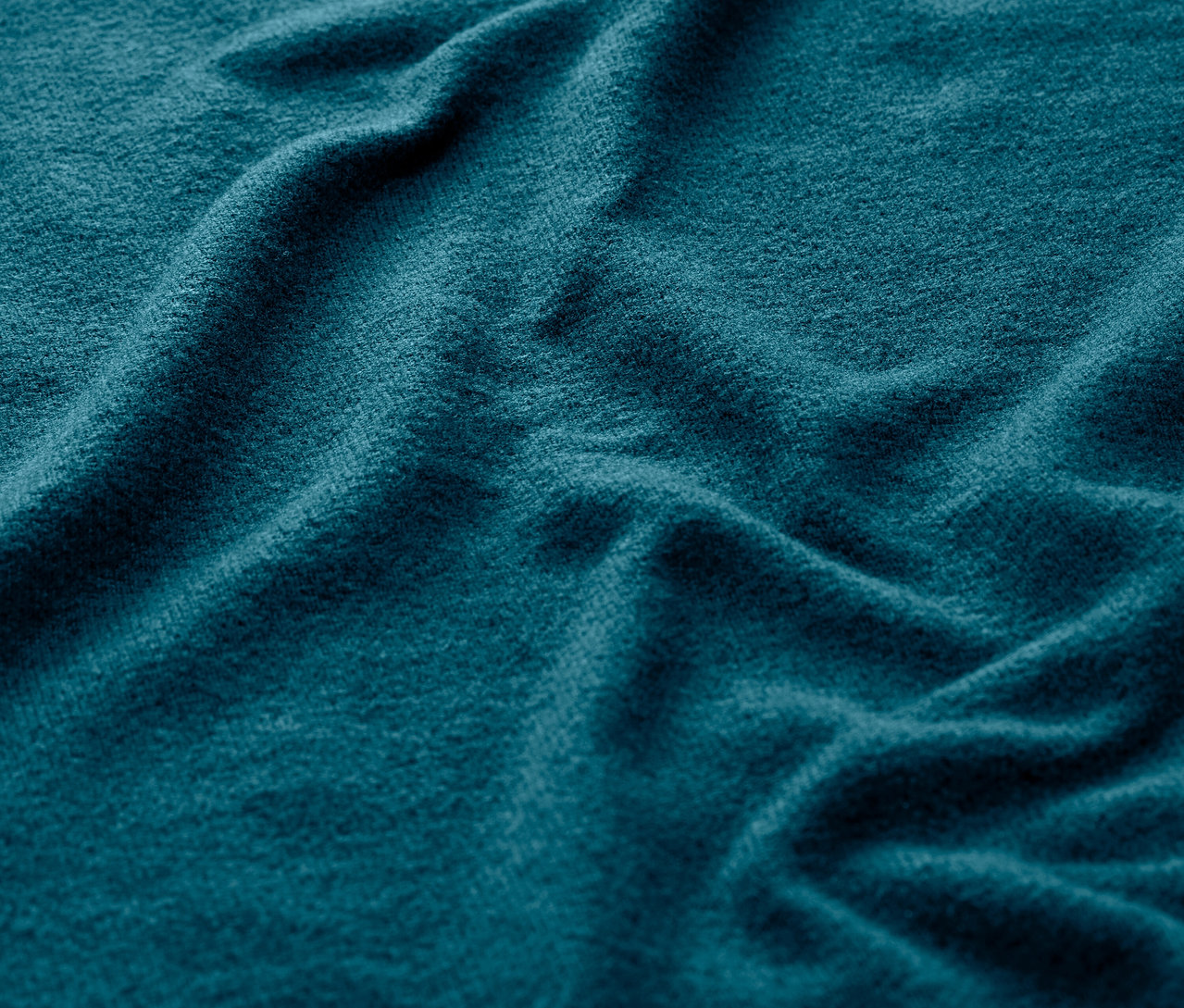 Nahaufnahme eines petrolfarbenen, superweichen Langarm-Sportshirts.