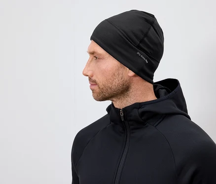 Profil eines Mannes mit Bart, der eine schwarze Dry Active Plus Mütze und einen schwarzen Kapuzenpullover trägt.