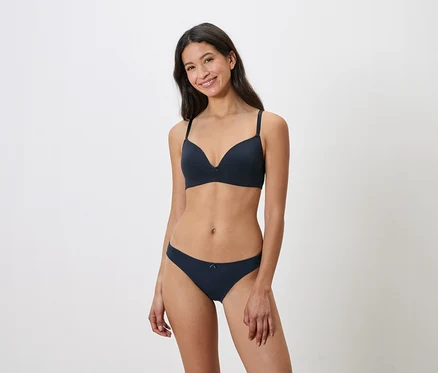 Frau trägt marineblauen BH und Unterhose.