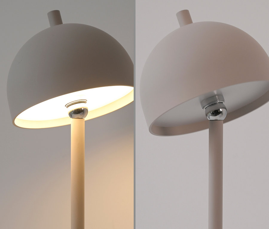 Nahaufnahme der SCHÖNER WOHNEN-Kollektion Akku-Tischleuchte »Bellis« in Sandbrise, wobei eine Seite beleuchtet ist und die andere nicht.