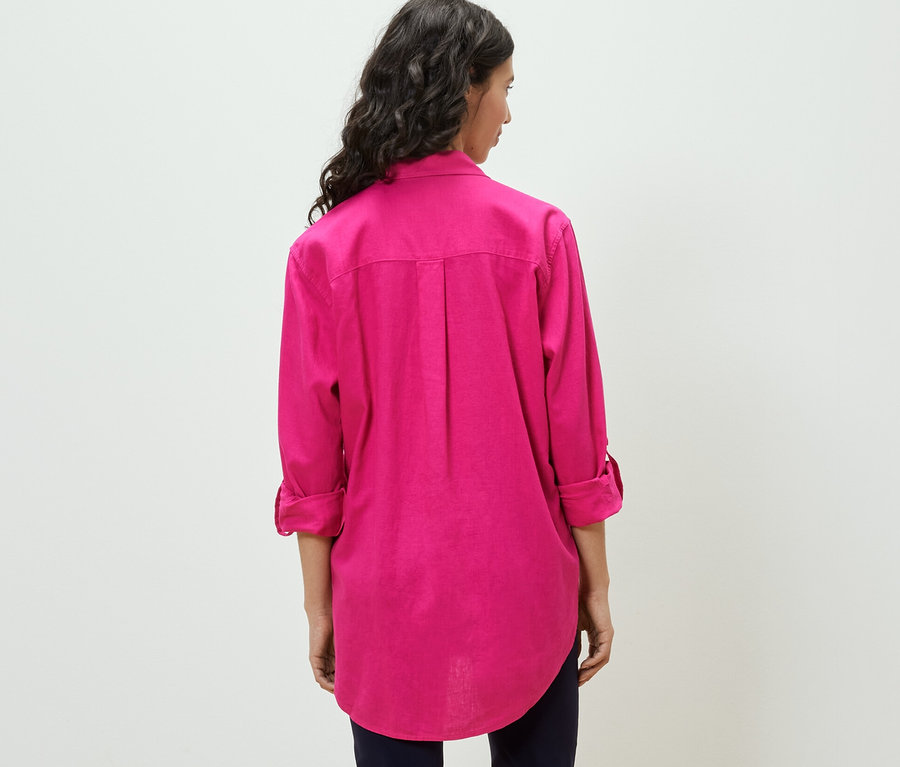 Frau trägt eine lange Leinenbluse, pink.