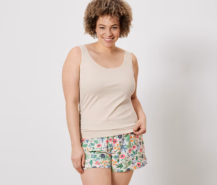 Frau trägt ein cremefarbenes Hemdchen und blumige Shorts von 2 Shorts und 2 Hemdchen.