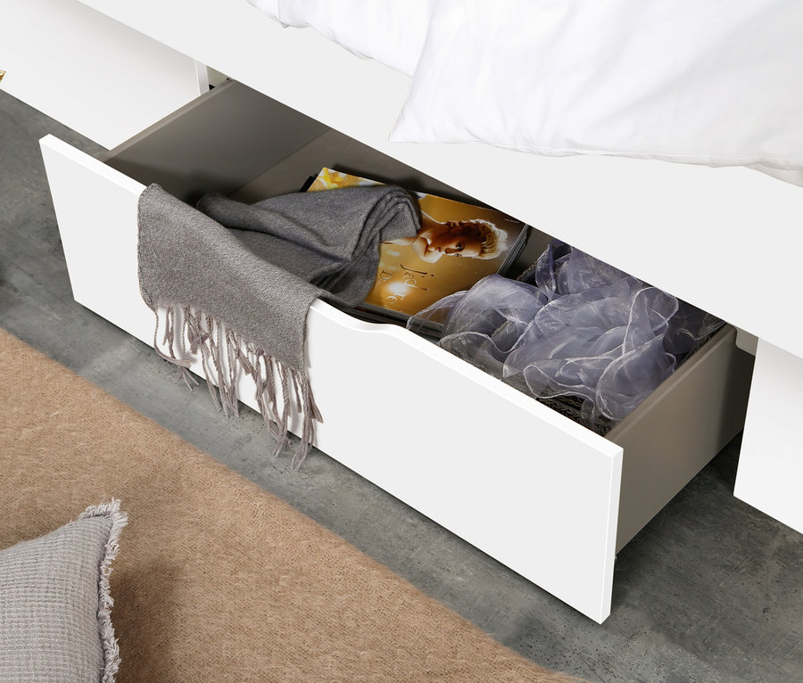 Detailaufnahme eines weißen Bettes mit offenem Stauraum, in dem sich Kleidung und Accessoires befinden. Rauch Bett »Aditio Beds«, 90 cm mit Polsterkopfteil ist sichtbar.